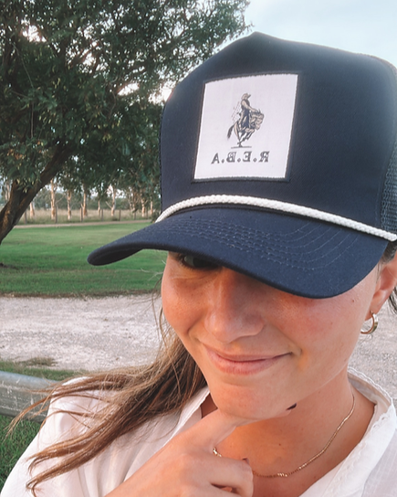 Person wearing a black cap with a logo outdoors